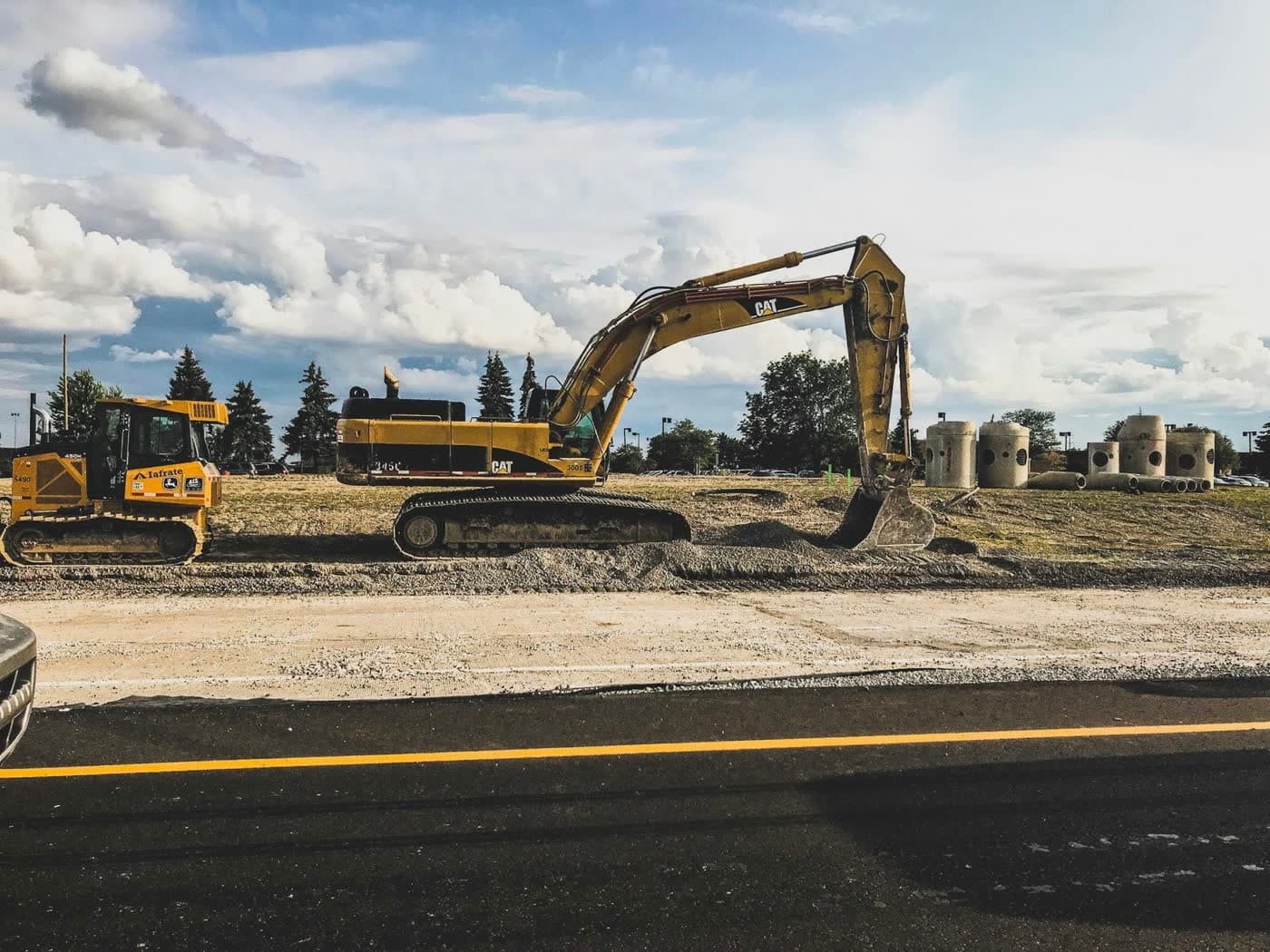 Cat excavator and dozer on a roadside jobsite — hydraulic equipment JSD services in the field.