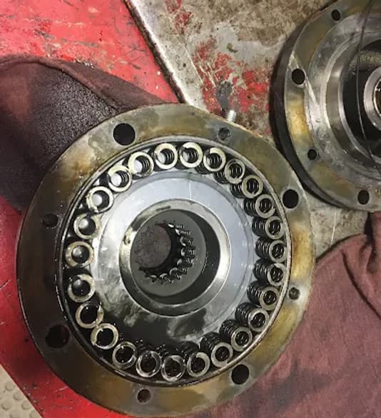Close-up of hydraulic brake components, showcasing disassembled parts and worn parts, relevant to JSD Equipment's hydraulic repair services.