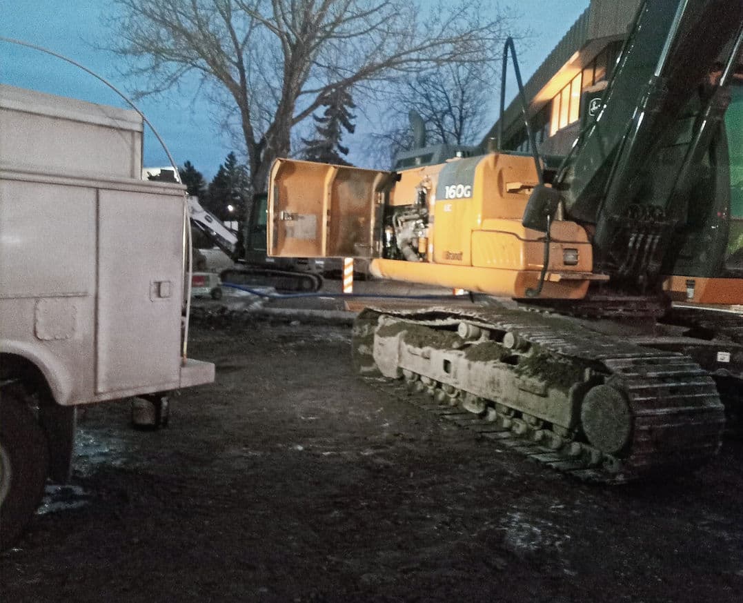 John Deere 160G LC excavator with service covers open during an evening repair call.