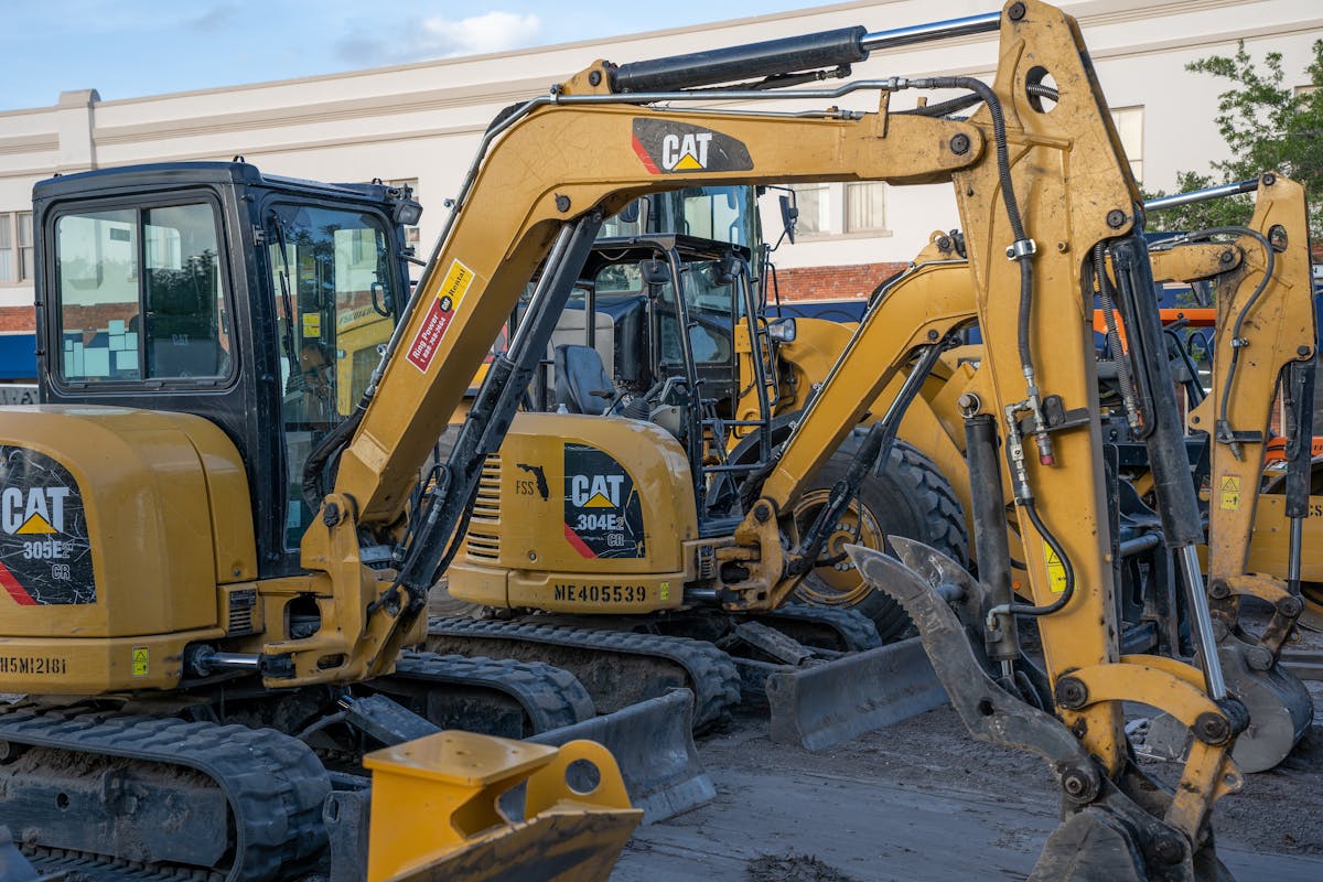Cat mini excavators lined up on a jobsite — compact equipment JSD services around Chilliwack.