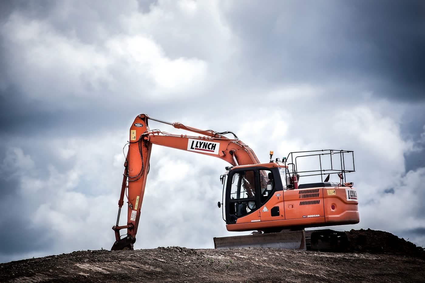 Tracked excavator parked on a dirt berm — heavy equipment kept reliable with scheduled maintenance.