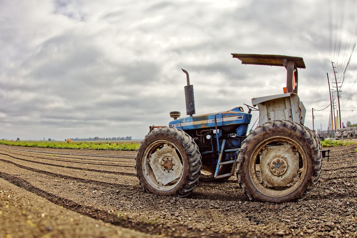 Vintage tractor parked on a freshly tilled field.
