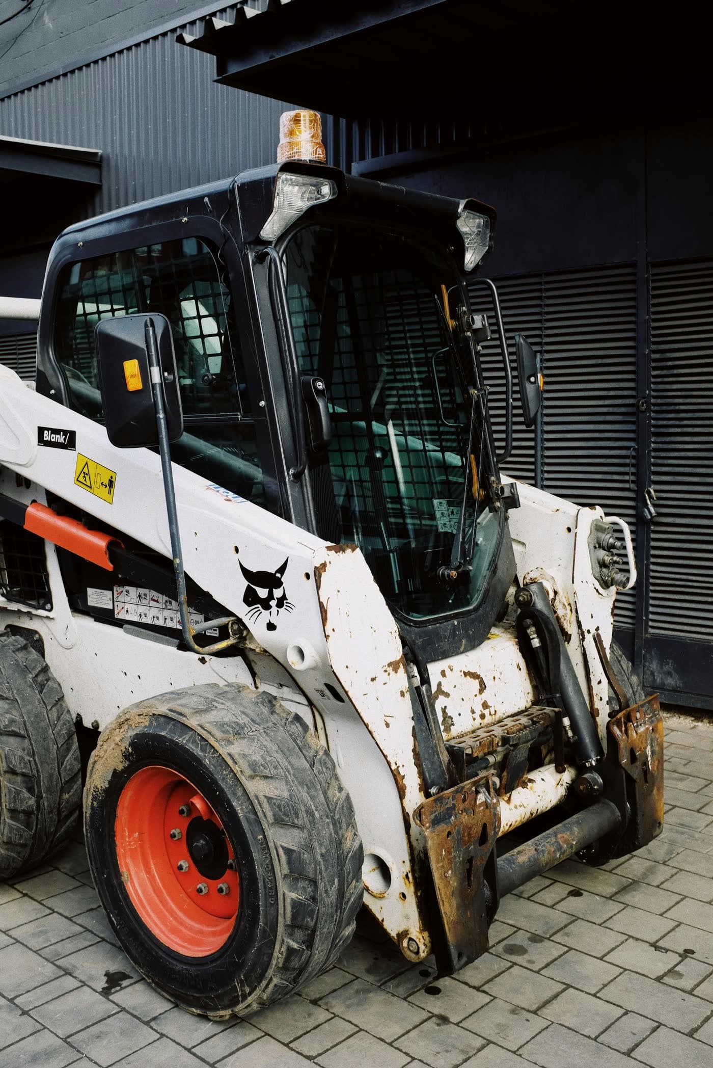 Front view of a Bobcat skid steer showing the lift arms, tires, and drive area.